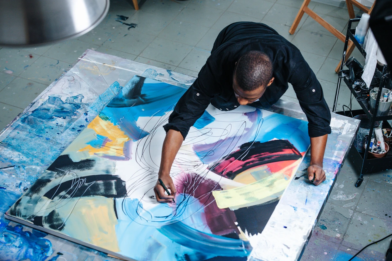 Black Creative Abroad painting while on the floor